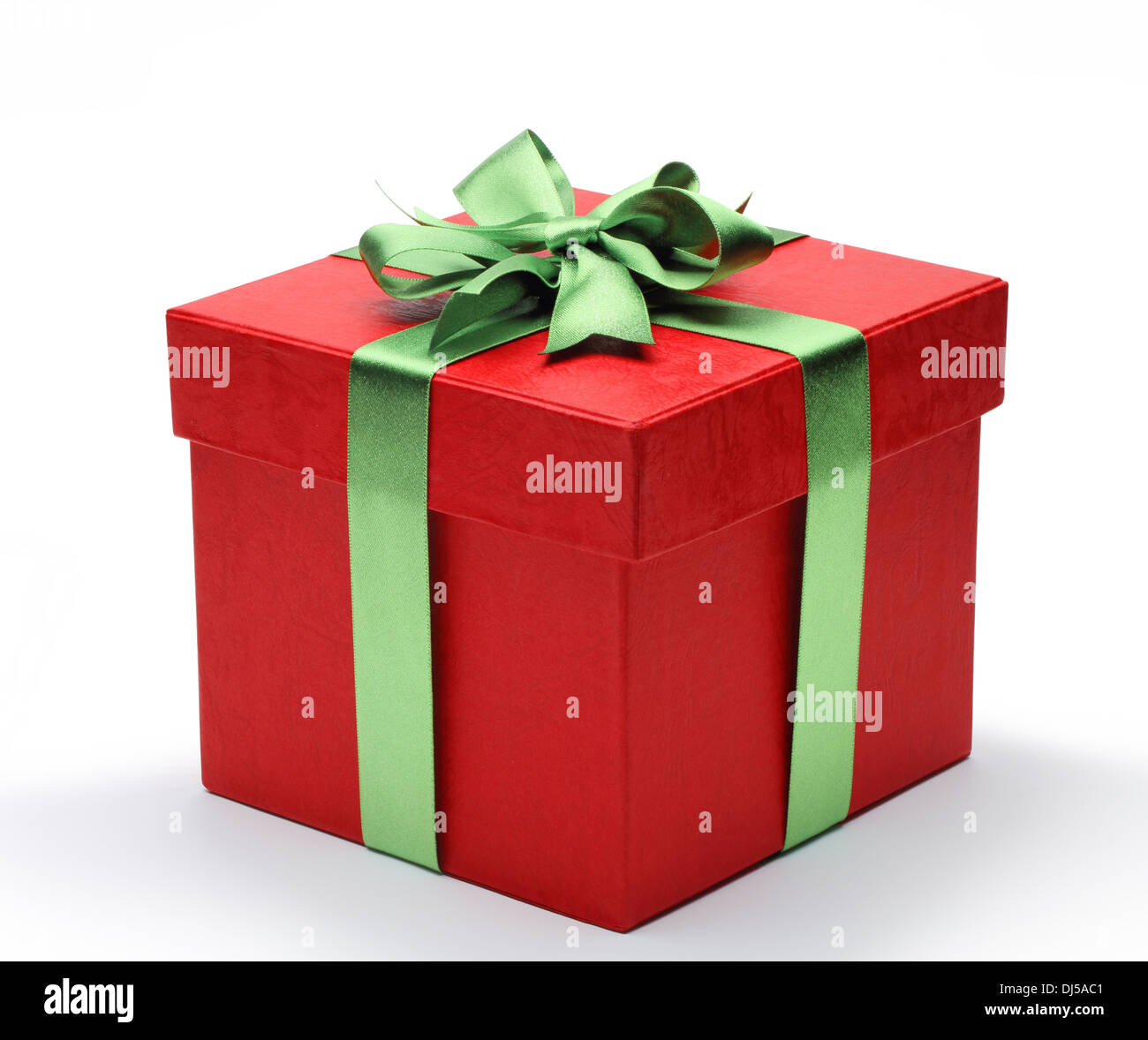 Red gift box with green ribbon bow, isolated on white background. Stock Photo