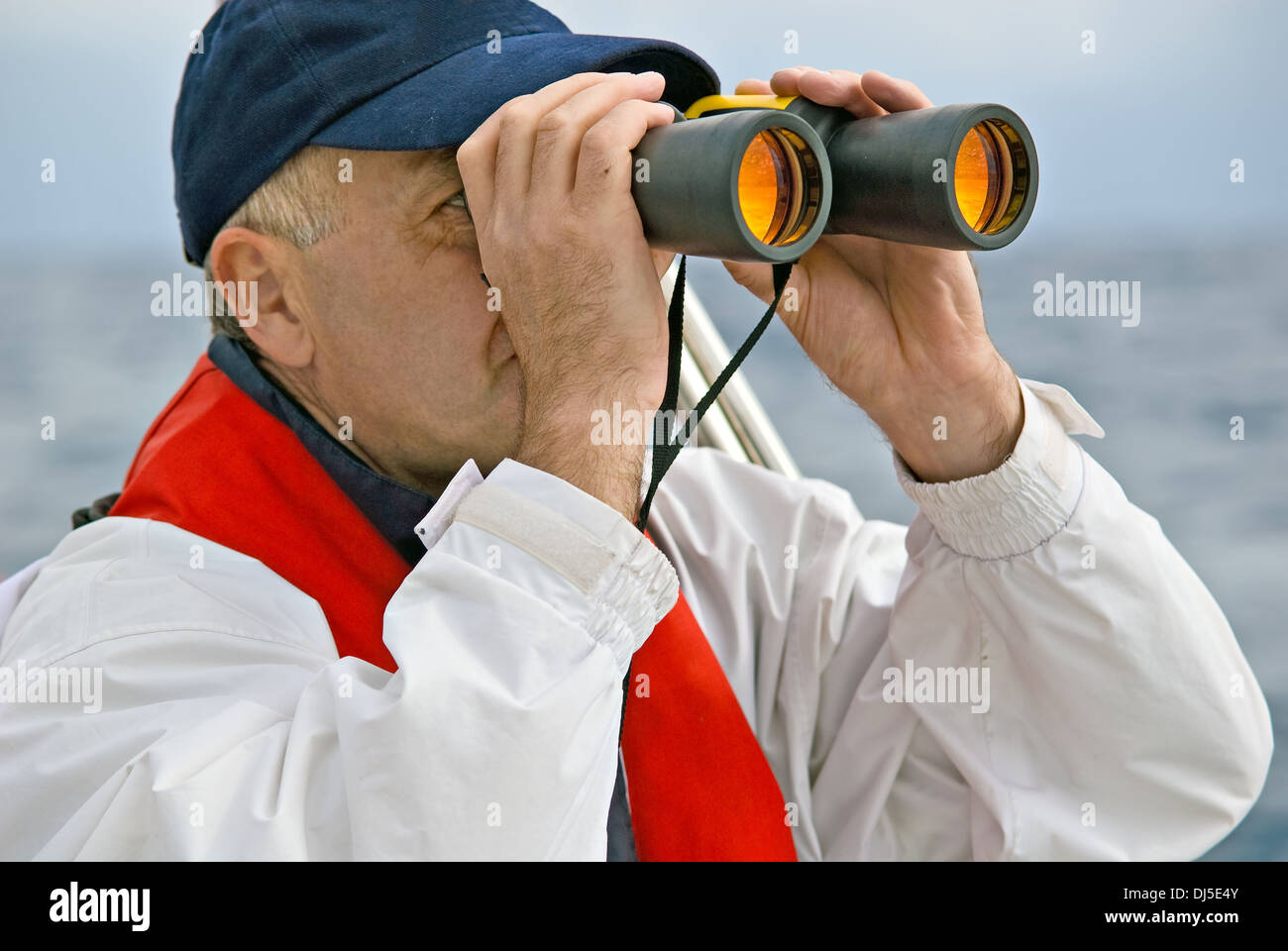 Man, 50 plus, looks through binoculars Stock Photo