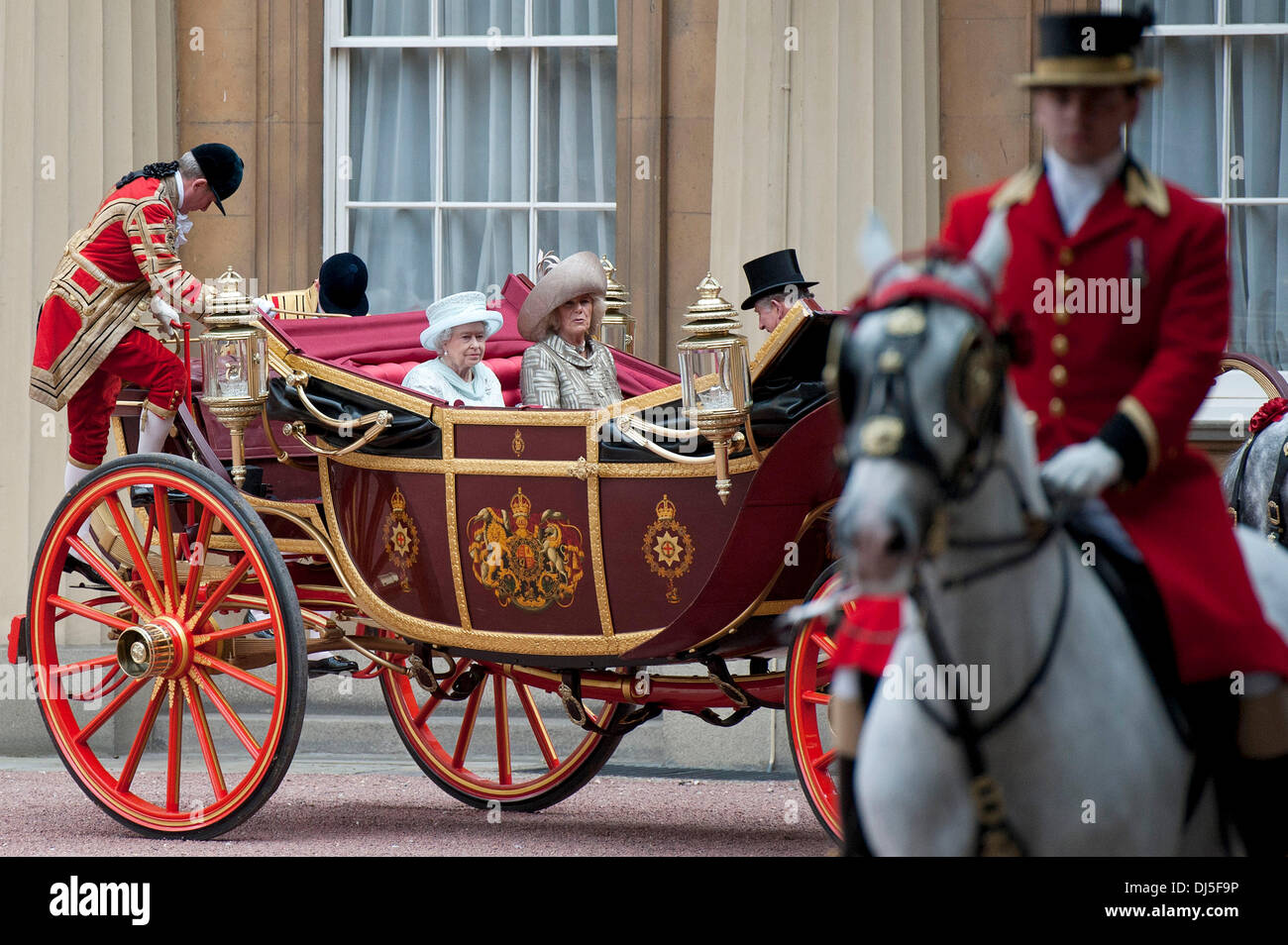 Footmen begin to dismount as Britain's Queen Elizabeth II, Camilla, Duchess of Cornwall, and Prince Charles, Prince of Wales, arrive at Buckingham Palace in the 1902 State Landau coach during a carriage procession from Westminster Hall to Buckingham Palac Stock Photo