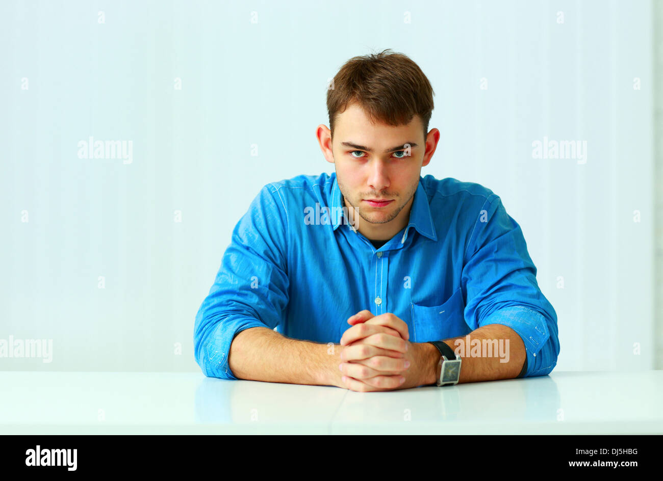 Portait of a young confident businessman sitting at the table in office Stock Photo