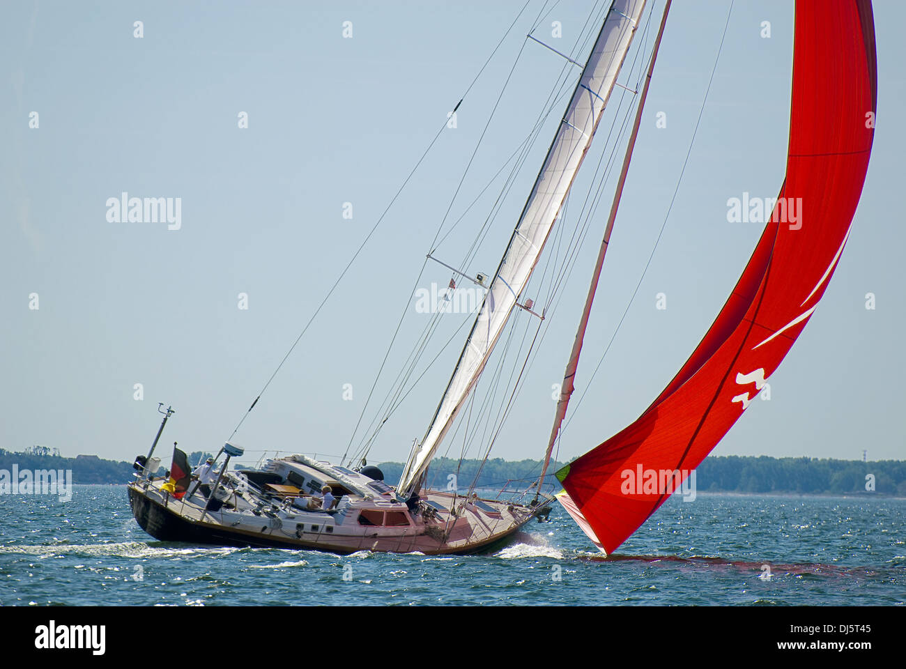sailing yacht with red spinnaker Stock Photo