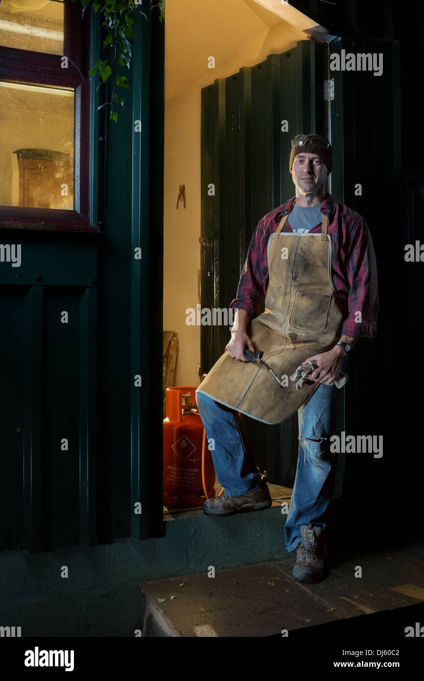 Craftsman standing outside his workshop. Stock Photo