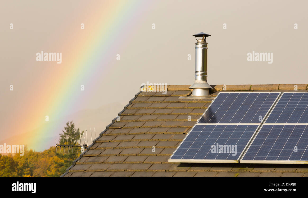 A rainbow over a house in Ambleside, with solar panels on the roof, Cumbria, UK. Stock Photo