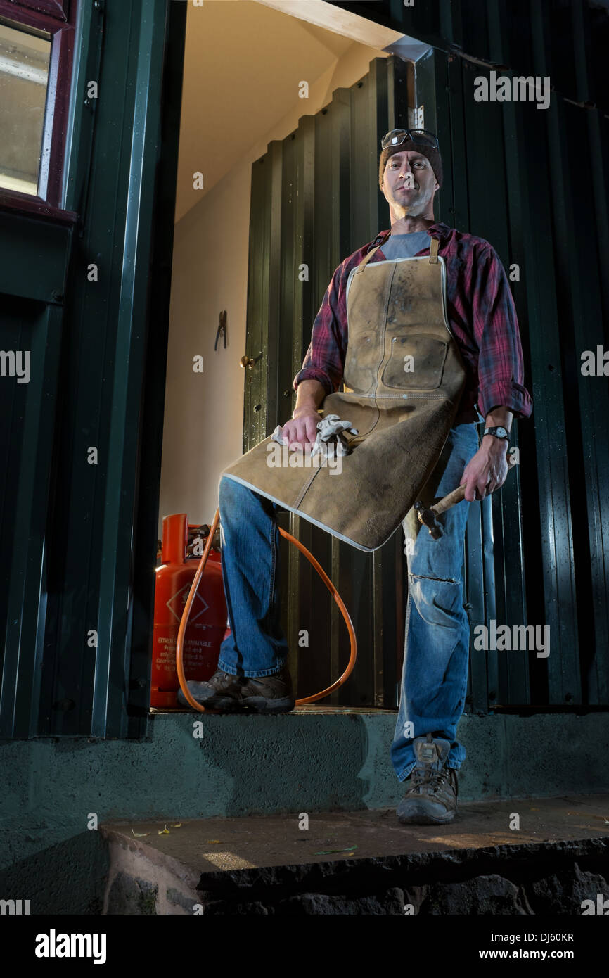 Craftsman standing outside his workshop. Stock Photo