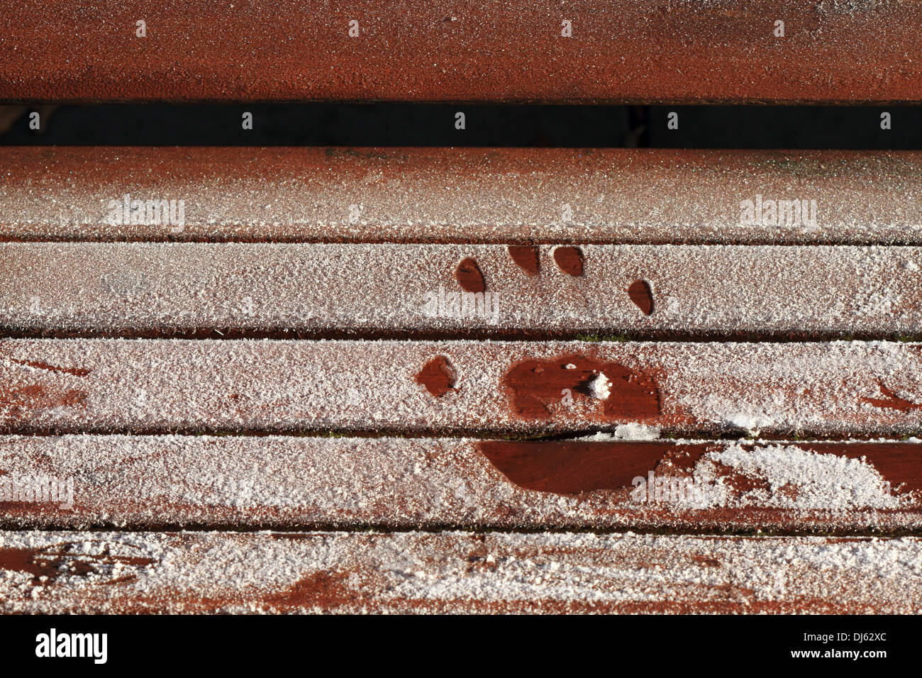 A small child hand print on a frosty icy park bench. Stock Photo