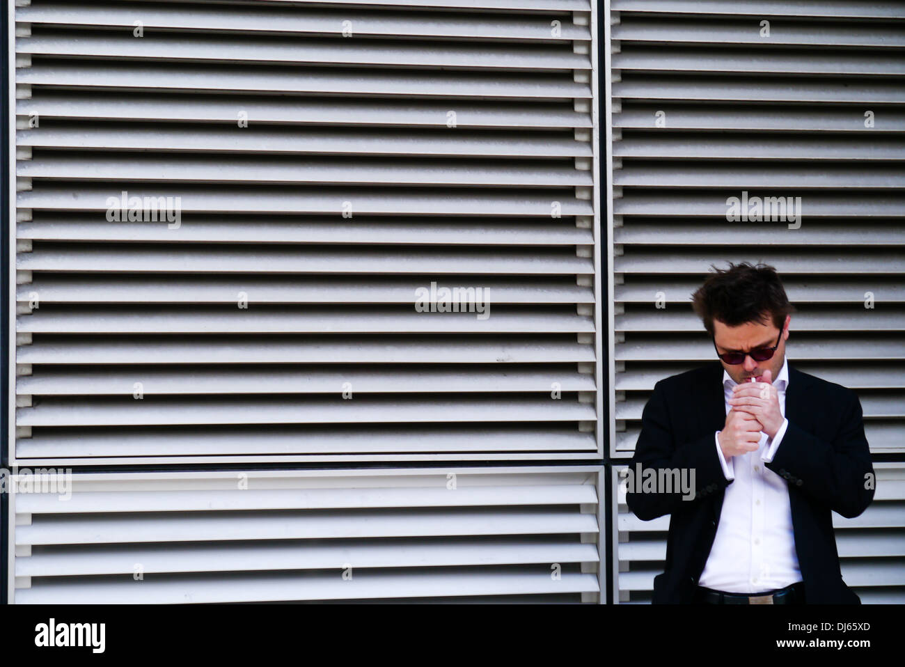 An office worker takes a break for a cigarette, City of London, Southbank, London Stock Photo