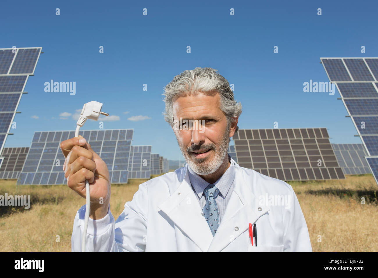 Scientist holding plug to solar panels Stock Photo
