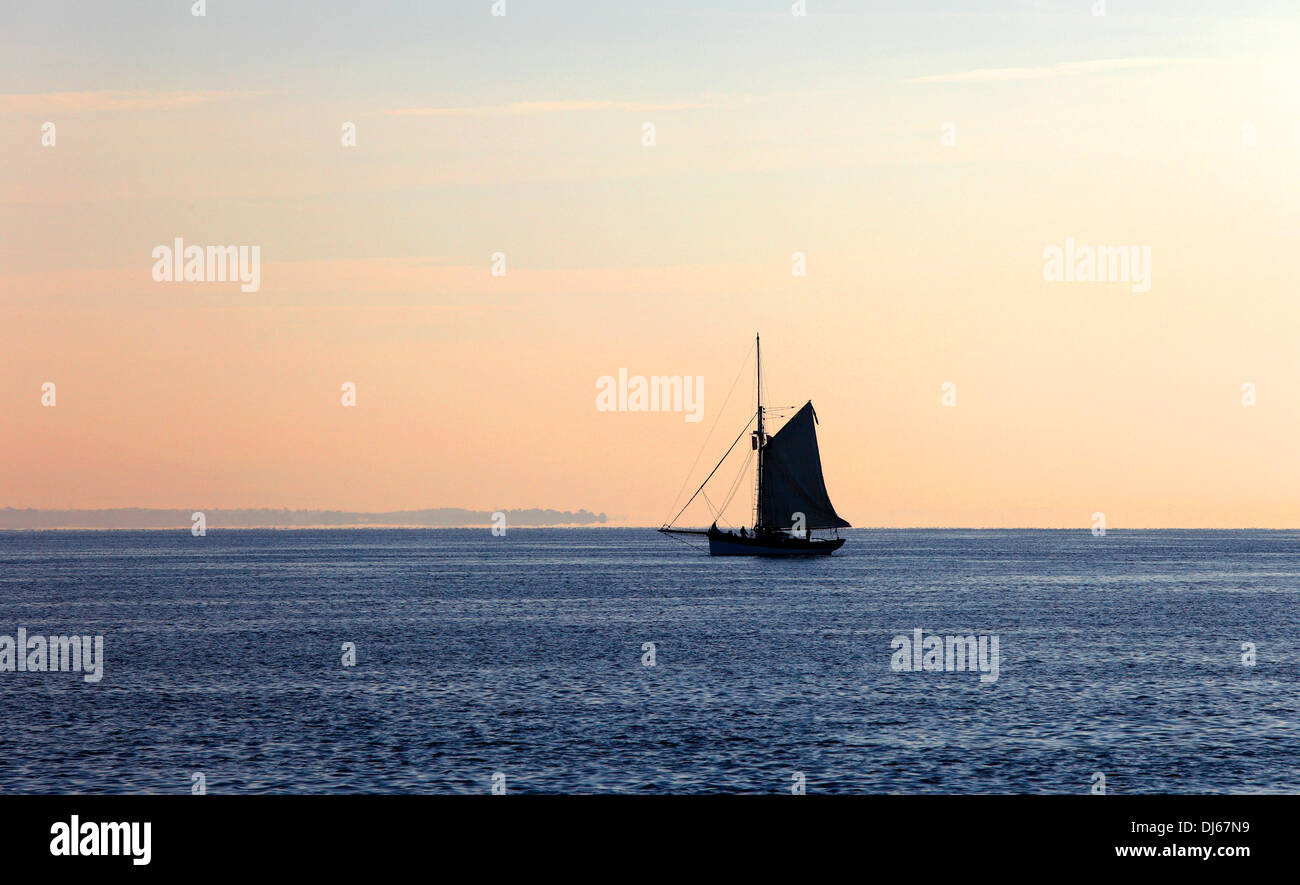 Sloop sailing on Solent in early morning light Solent Isle of Wight Hampshire England Stock Photo
