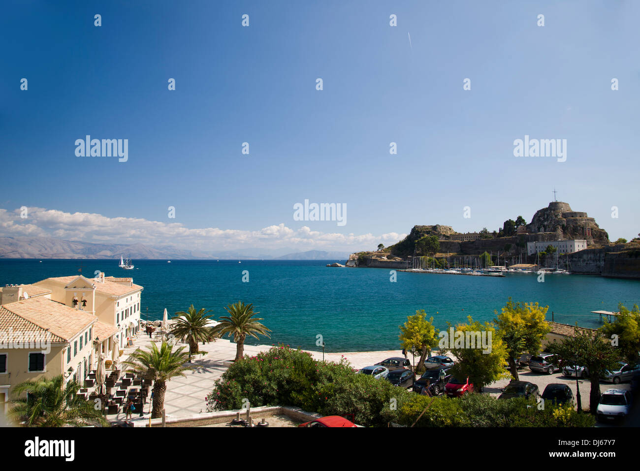 Corfu town fortress with a taverna in the foreground, blue sky and sea Stock Photo