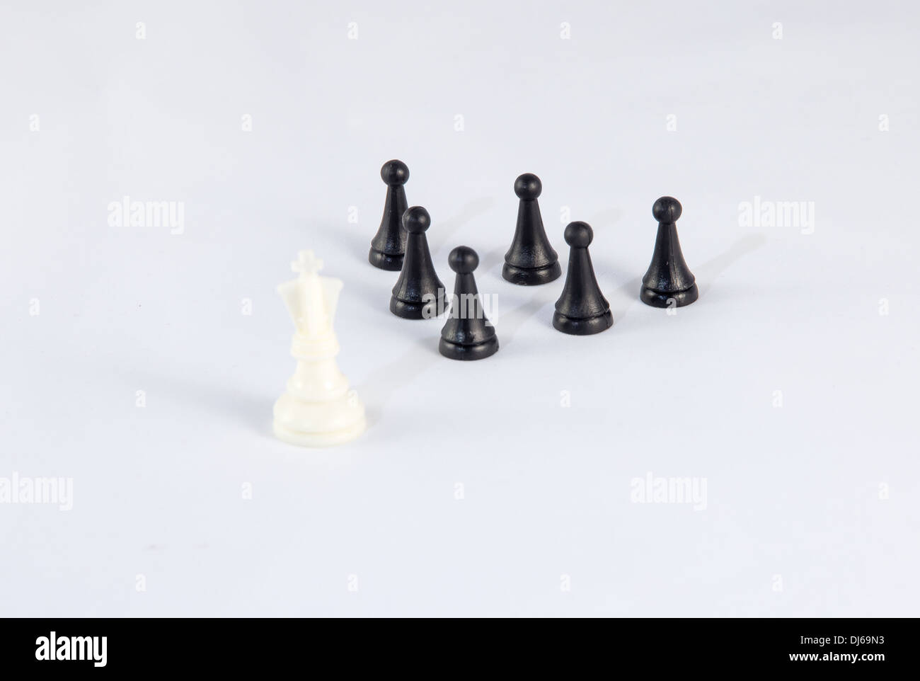 White chess king with black pawns symbolizing business leadership and difference Stock Photo