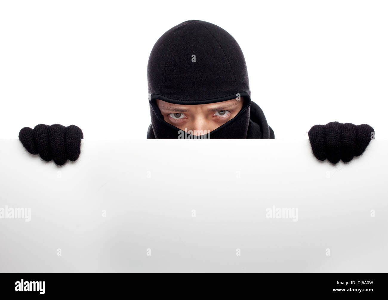 Robber hiding behind a empty white  space for text Stock Photo