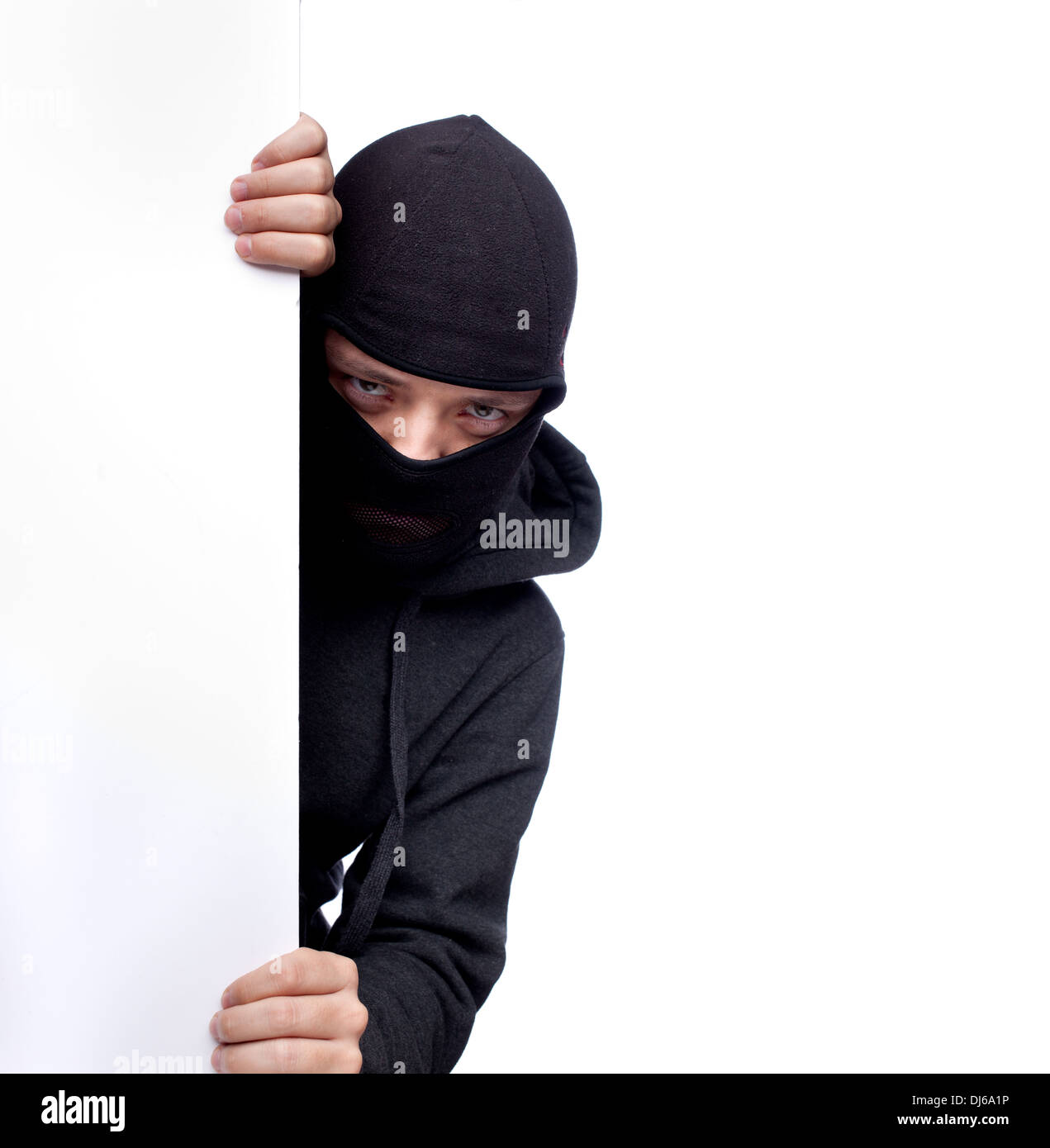 Robber hiding behind a empty white  space for text Stock Photo