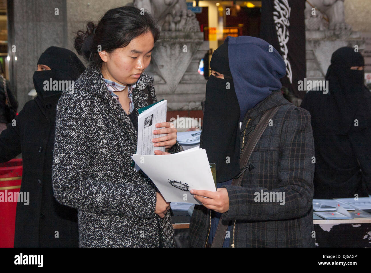 London, 22 November 2013. A woman from radical Islamist preacher Anjem Choudary's  Islam4UK speaks to a member of the public during a protest and leafleting outreach in Chinatown to highlight the persecution of Muslims in China. Credit:  Paul Davey/Alamy Live News Stock Photo