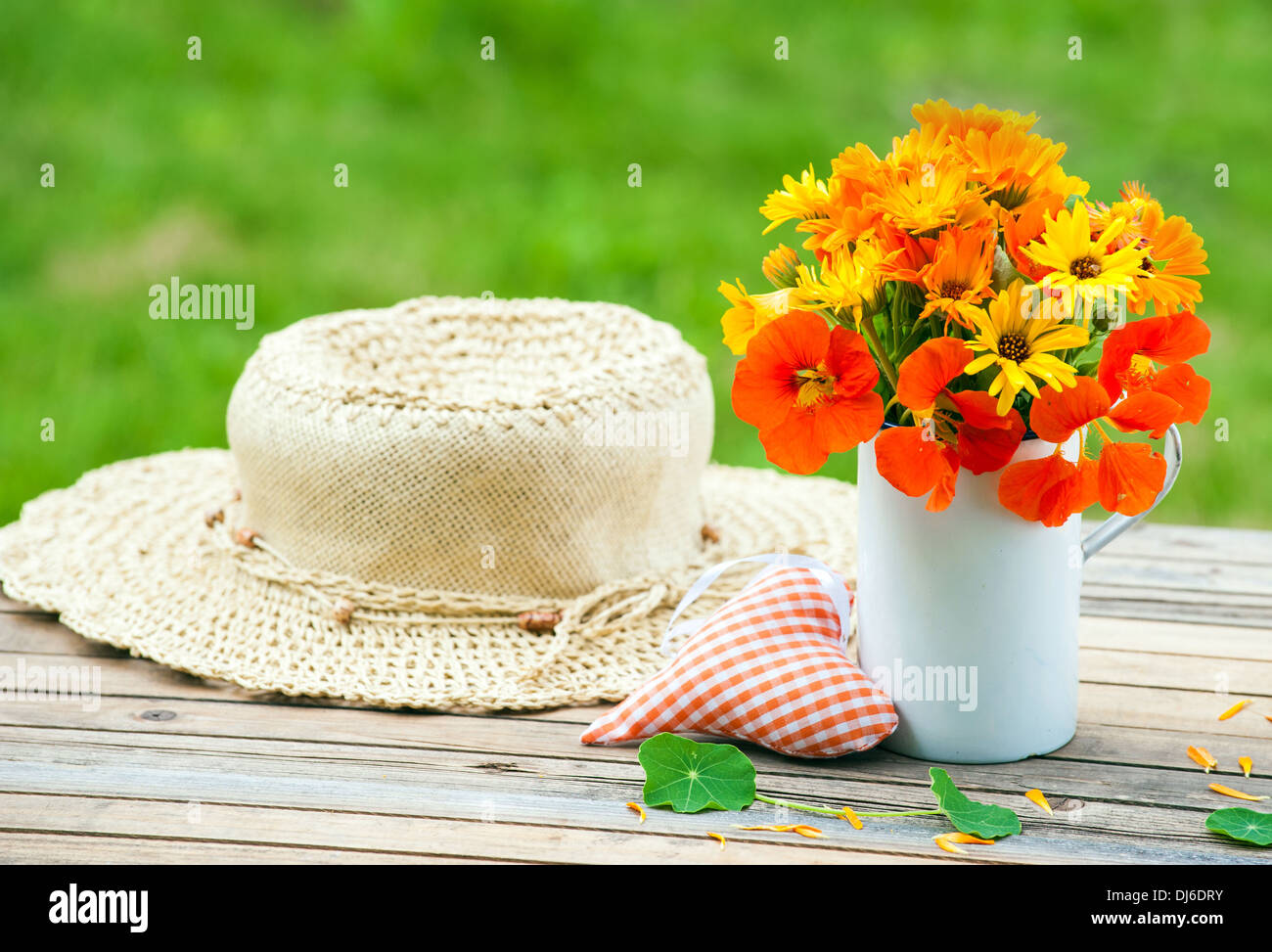 Marigolds and nasturtiums in an old cup on a table Stock Photo Alamy