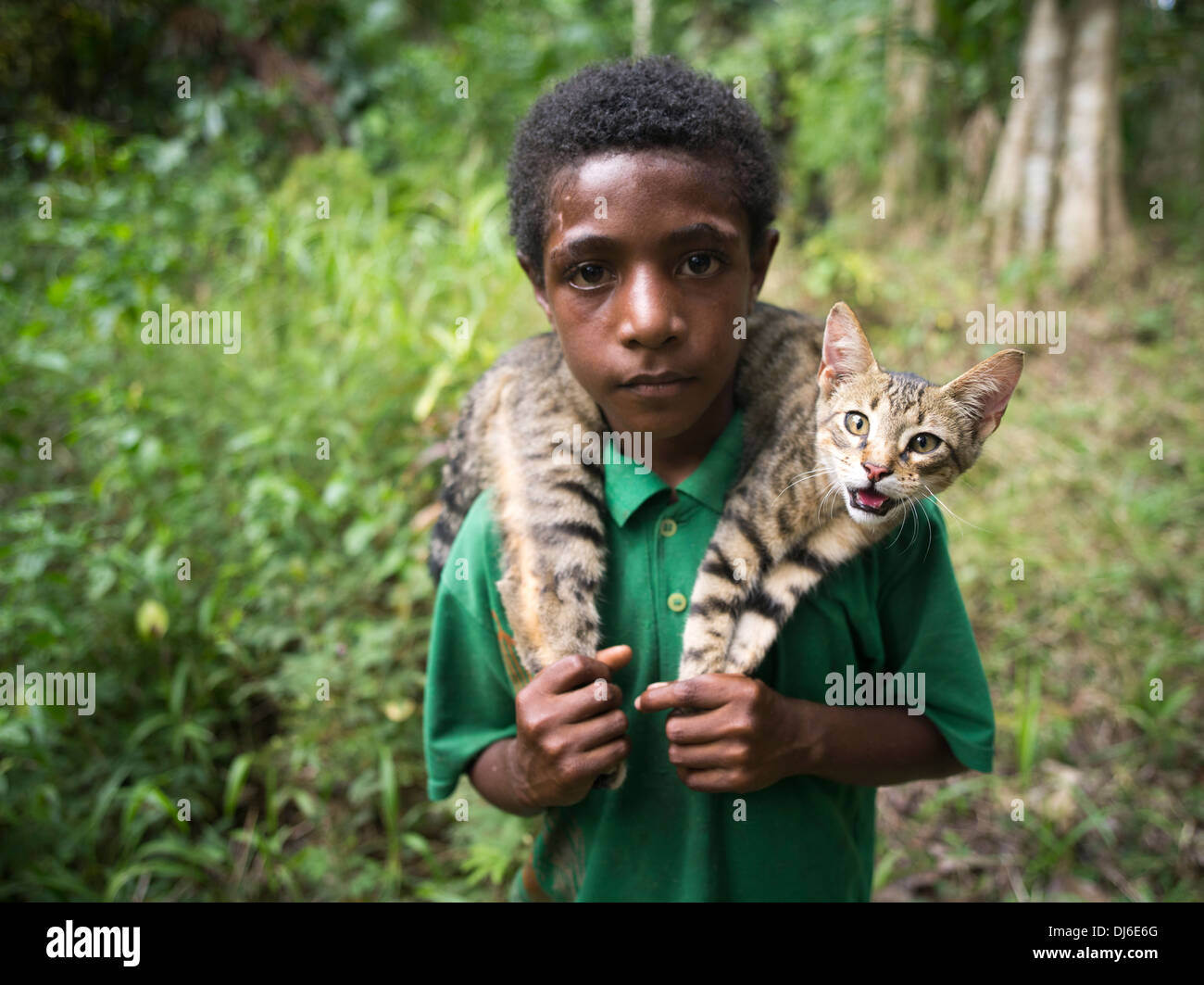 Boy with cat in jungle near Madang, Papua New Guinea Stock Photo