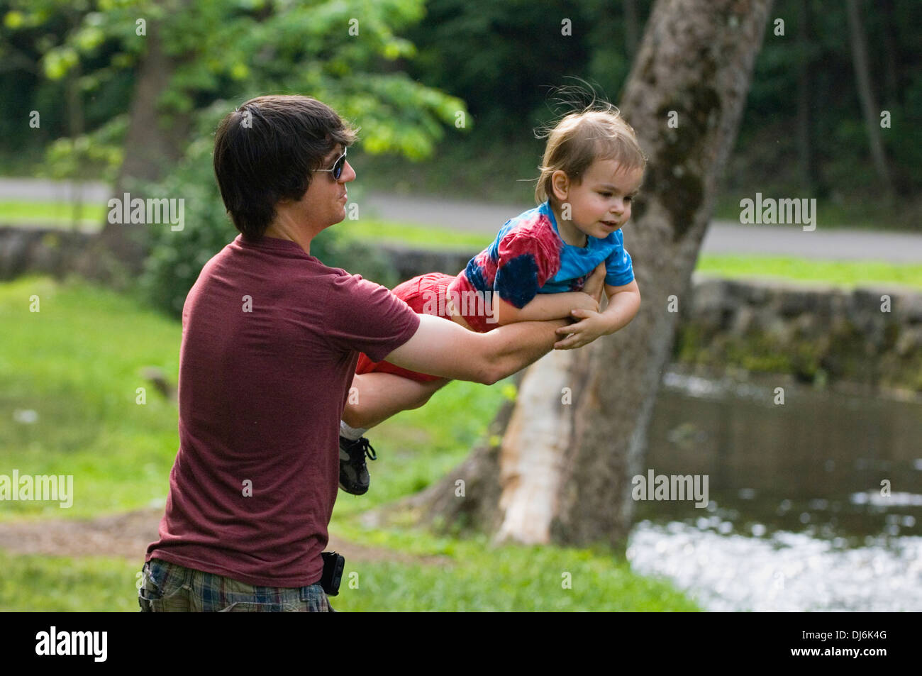 Father Playing with Toddler Son beside Creek at Spring Mill State Park in Indiana Stock Photo