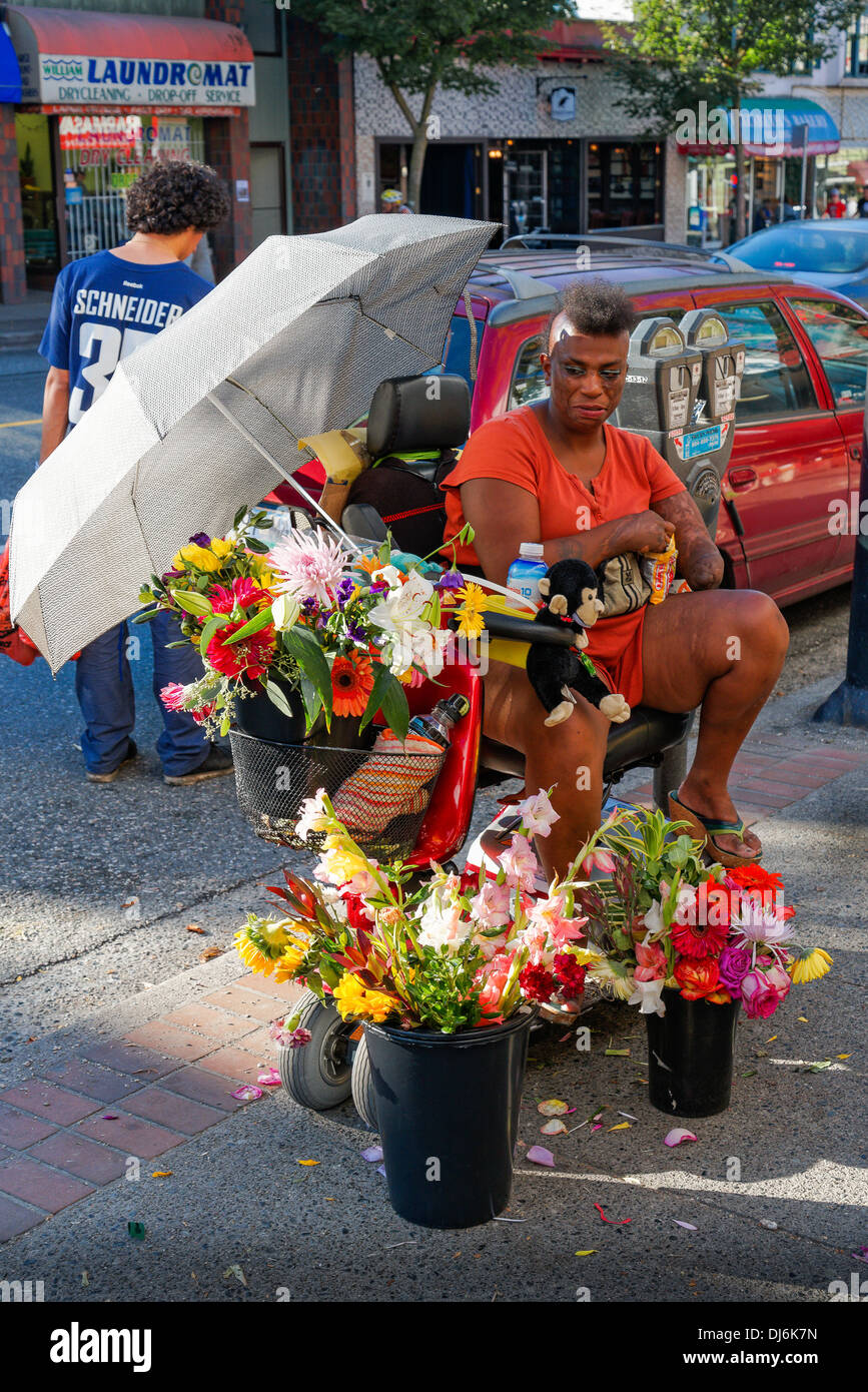Woman with amputated forearm selling flowers on sidewalk, Stock Photo