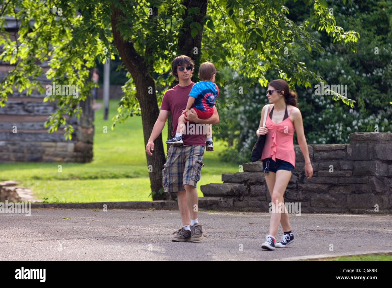 Young Couple Walking and Holding Toddler Son at Spring Mill State Park in Indiana Stock Photo