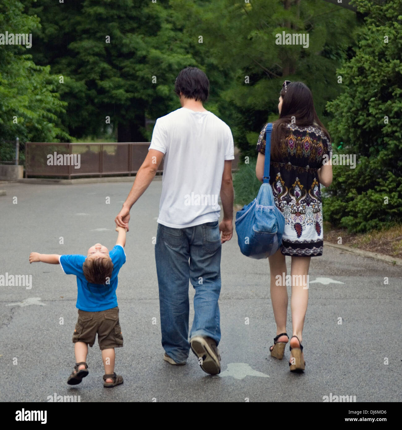 Young Family with Two Year Old Boy Walking in the Rain at the Zoo Stock Photo