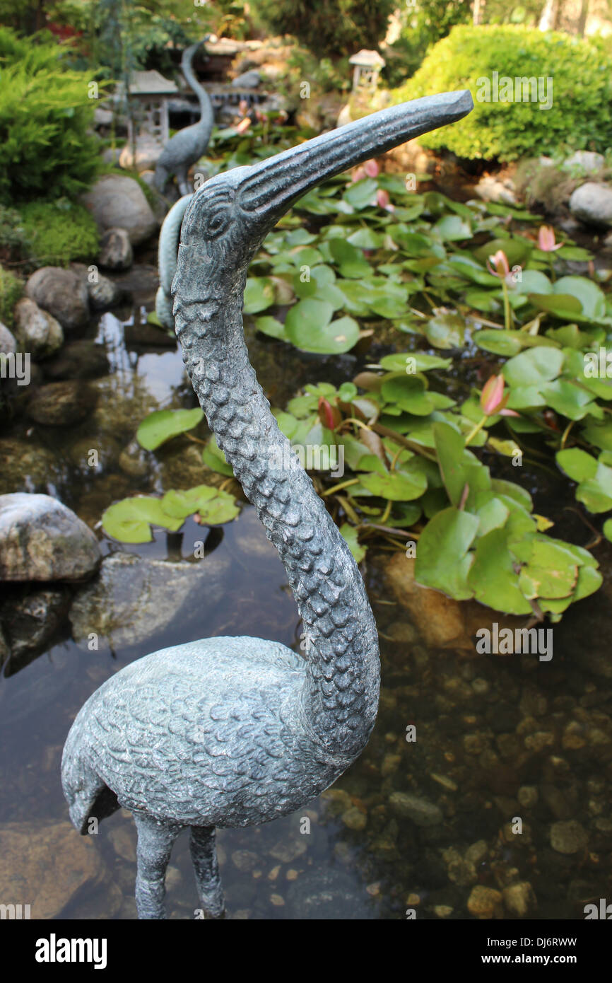 A statue of a wading bird in a pond. Stock Photo