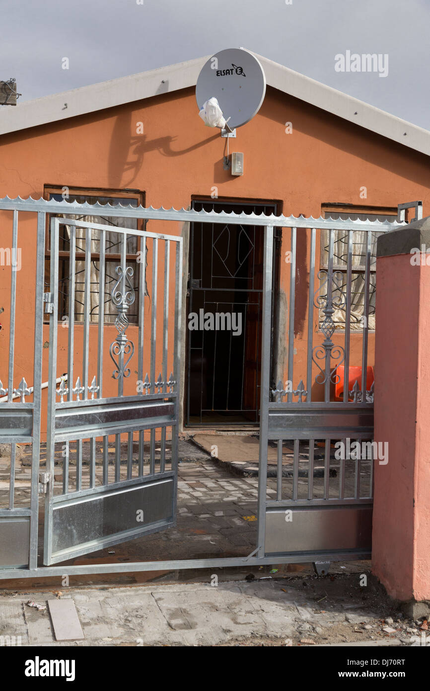 South Africa, Cape Town, Guguletu Township. Middle-class House with Satellite Dish and Security Gate. Stock Photo