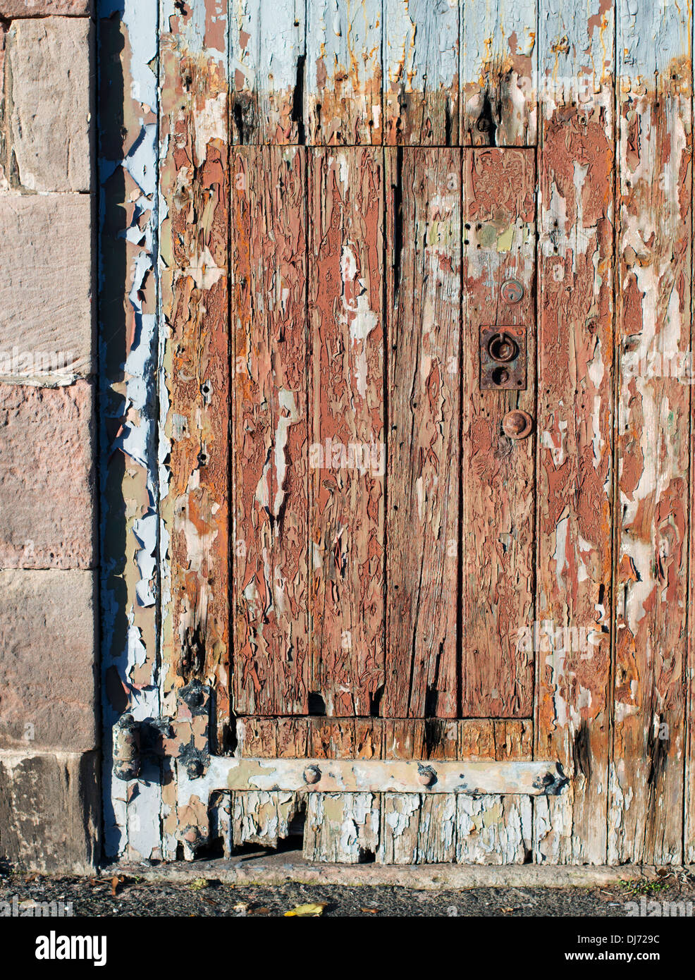 Old wooden door flaking paint Berwick upon Tweed, Northumberland, England, UK Stock Photo