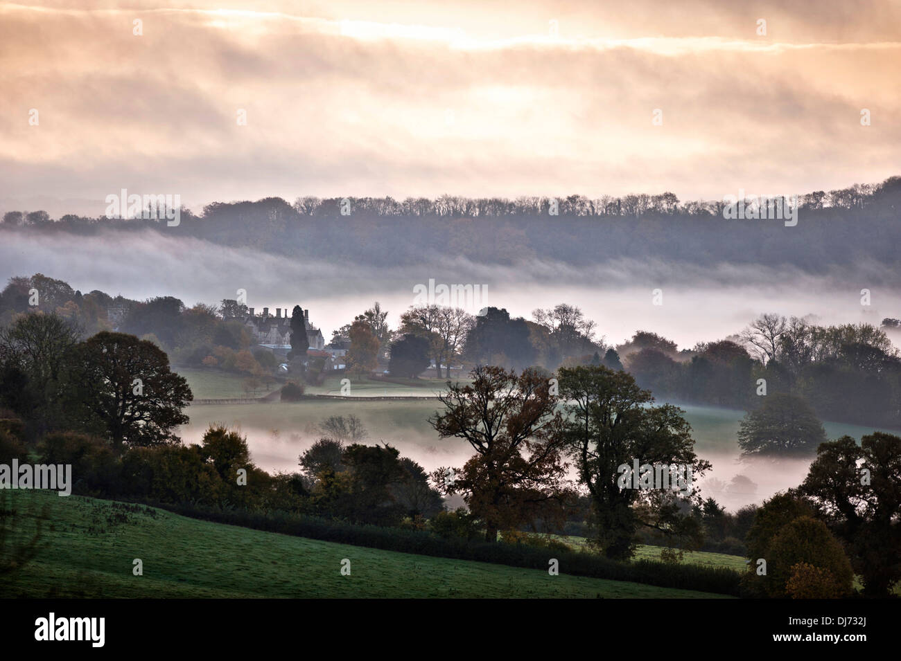 A misty dawn view of Alderley House near Wotton-under-Edge, Gloucestershire UK Stock Photo