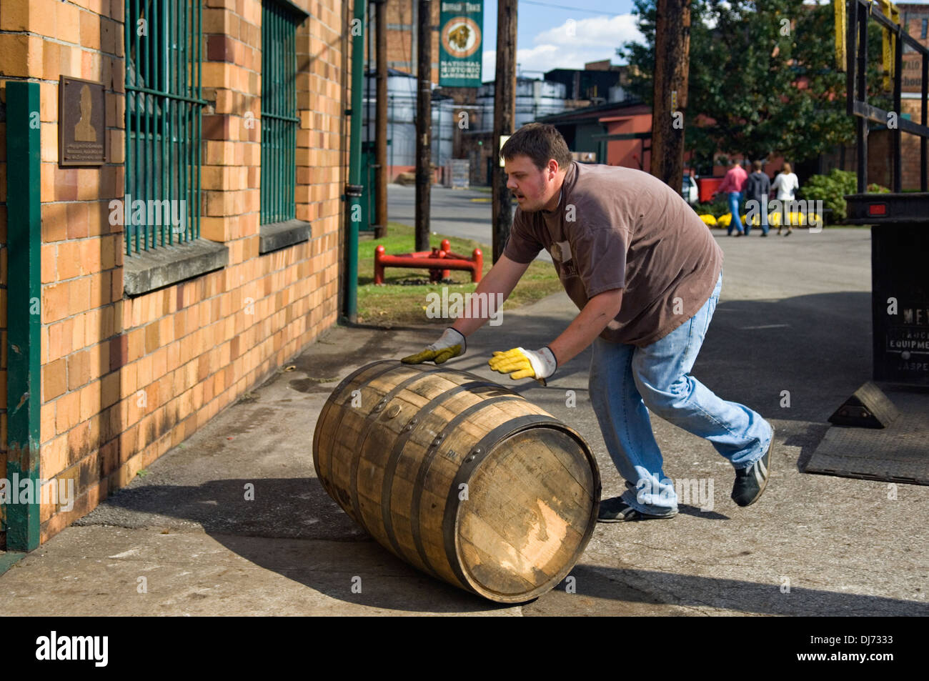 Worker at Buffalo Trace Distillery Rolling Barrel of Bourbon into Storage Building in Frankfort, Kentucky Stock Photo