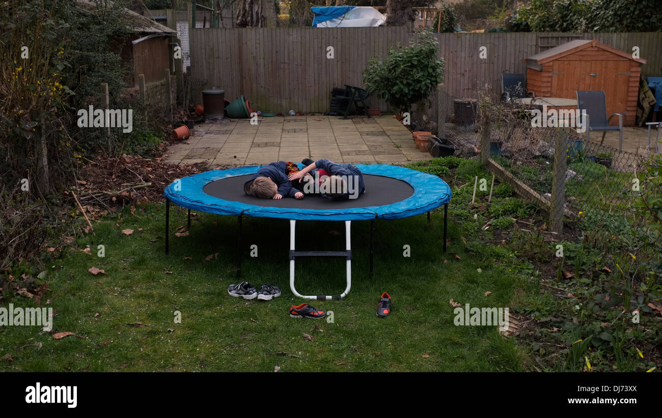 Two boys (brothers) being rowdy on a large trampoline in their back garden.  Please credit photo by Paul Treacy Stock Photo - Alamy
