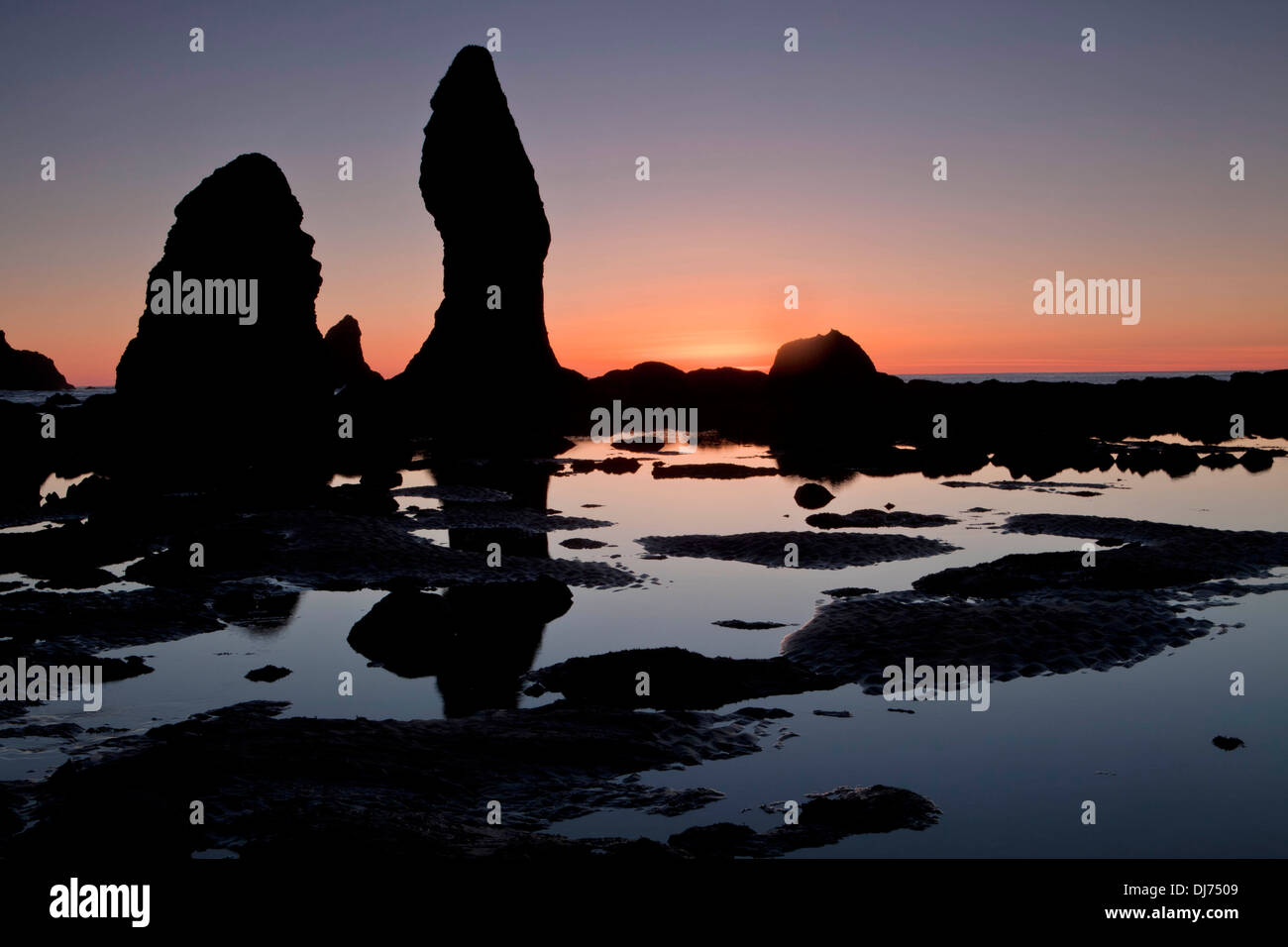 The sun sets behind a sea stack at Point of the Arches along Shi Shi Beach, Olympic National Park, Washington. Stock Photo