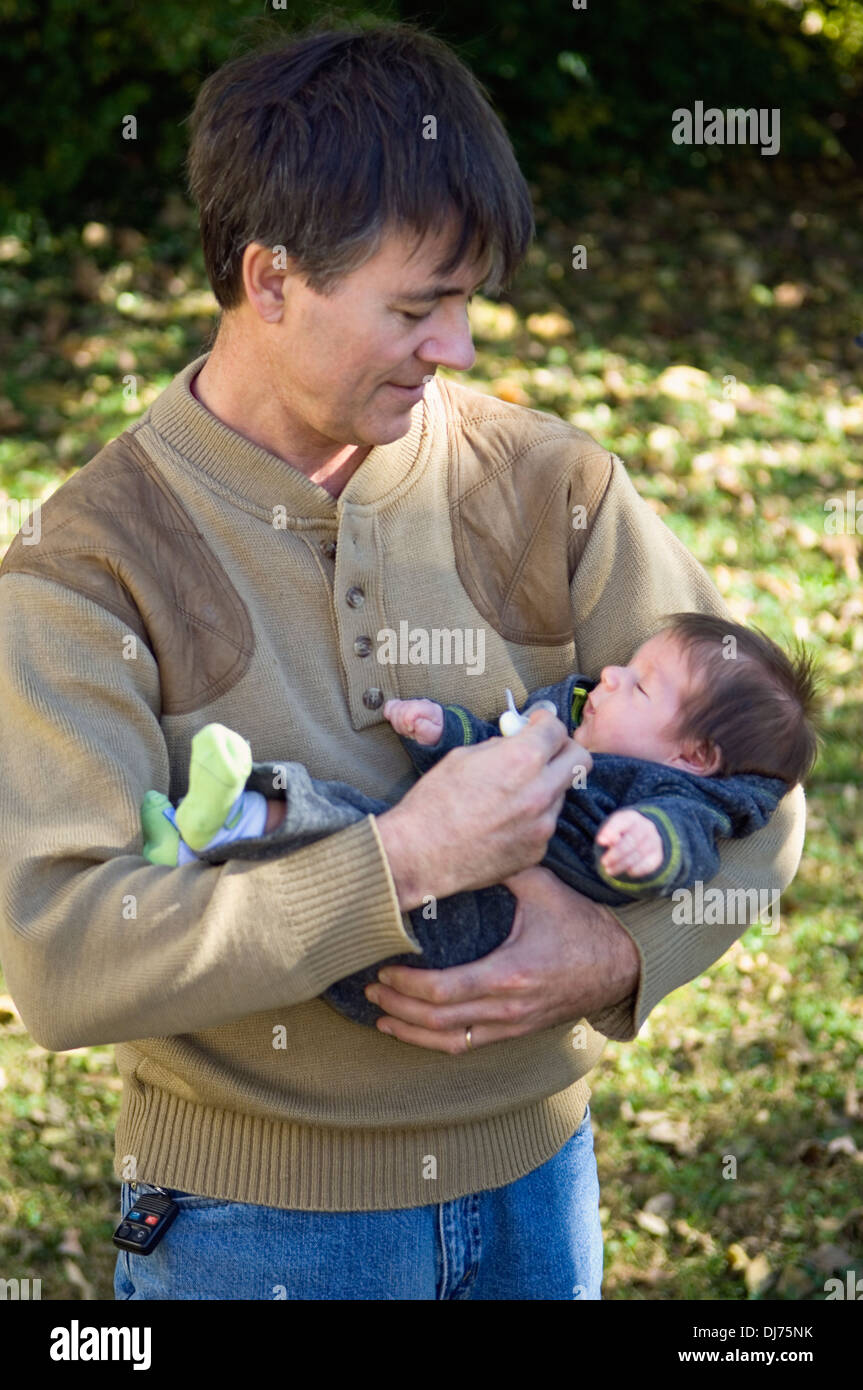 Grandfather Holding New Grandson Stock Photo