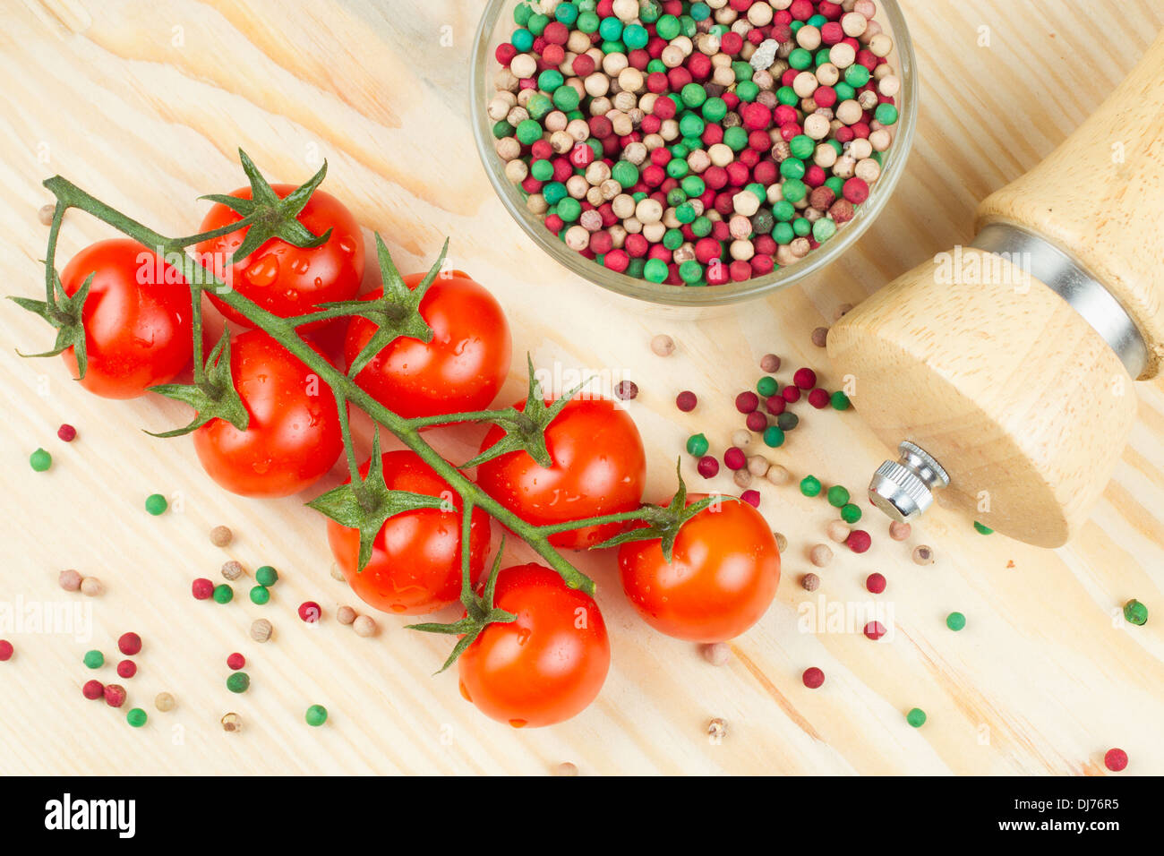 cherry tomatoes with pepper grain on wooden chopping board Stock Photo ...