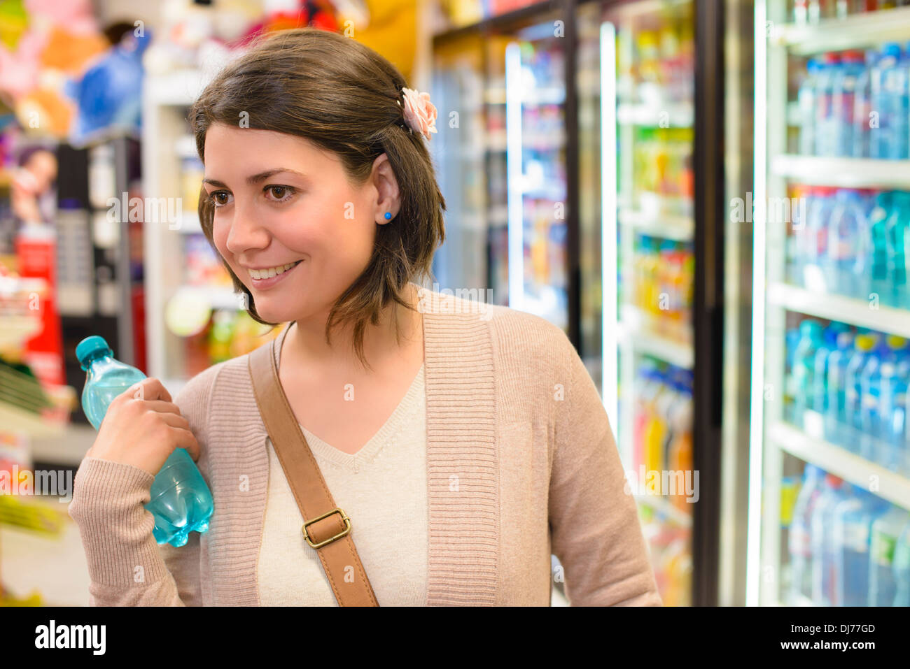 Young woman buying a bottle of water from a store Stock Photo