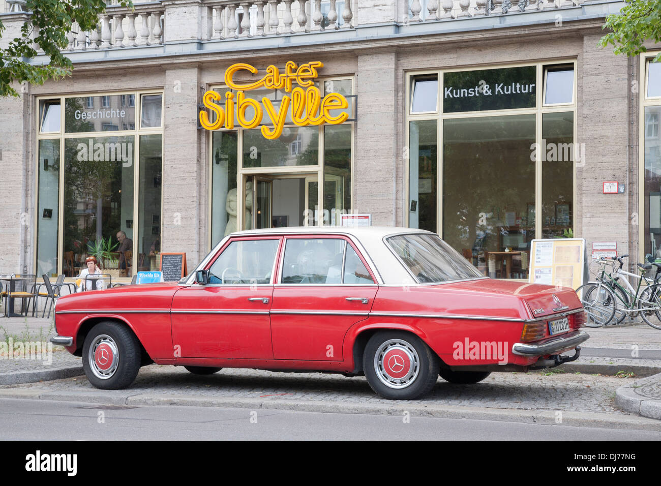 Cafe Sibylle, Karl Marx Allee Street, Berlin; Germany with Old Red Mercedes Car Stock Photo