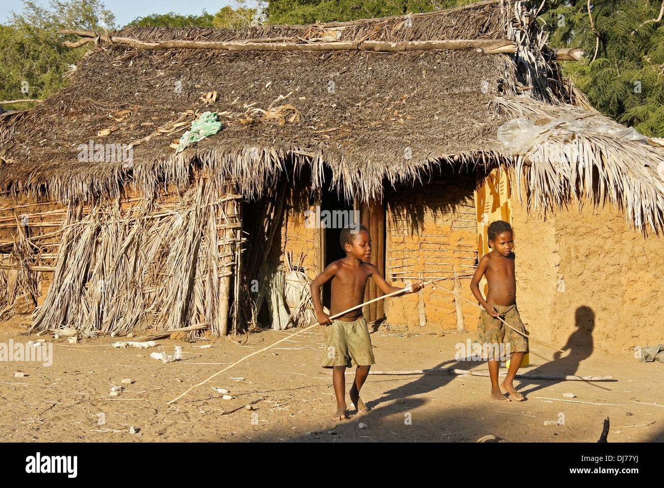 Malagasy boys playing in front of thatched hut, Morondava, Madagascar Stock Photo