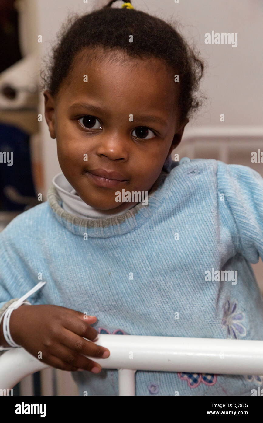 South Africa, Cape Town. Little Girl Standing in her Bed Stock Photo