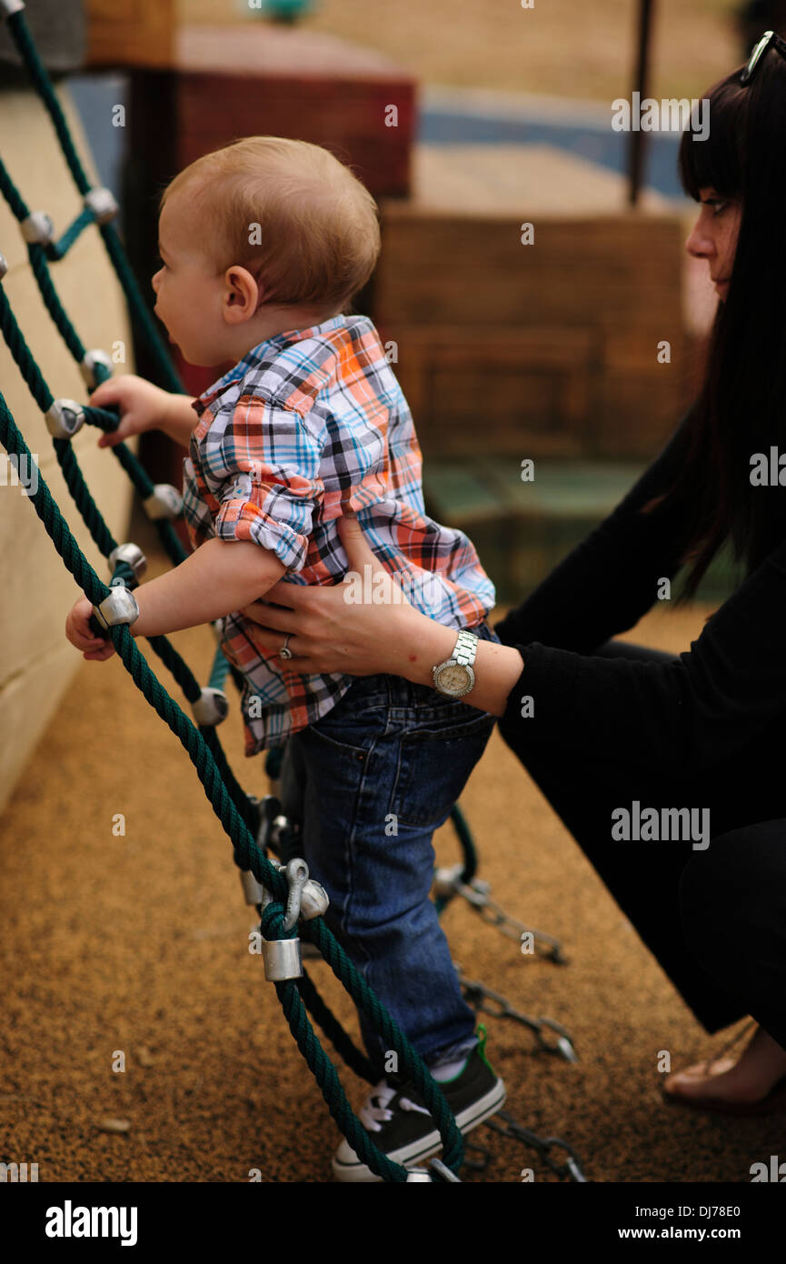 A young toddler strives to climb the ladder to reach the next level he
