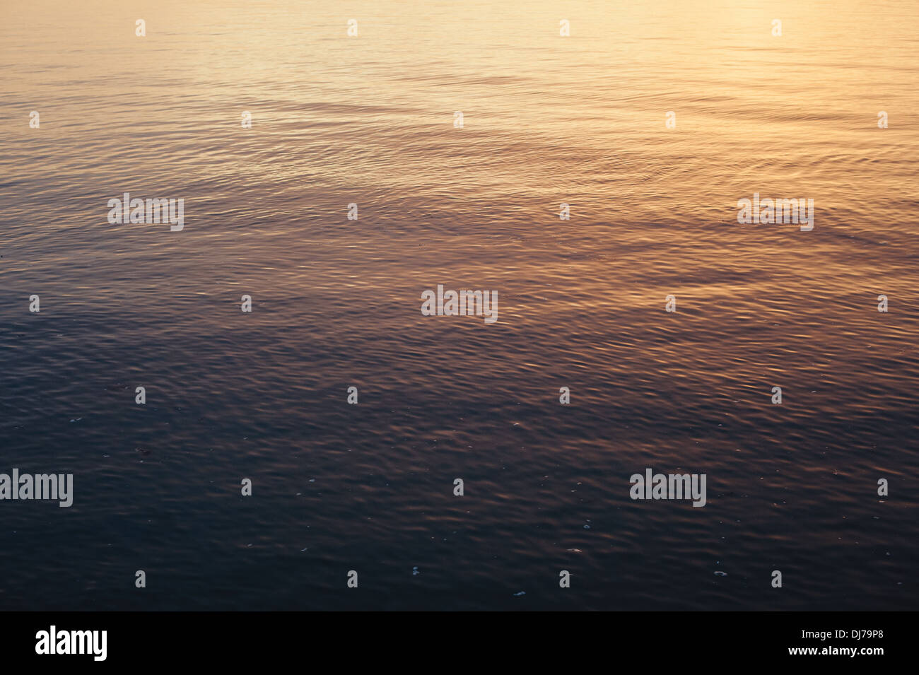 Small waves and patterns in the calm sea during a sunset at Whitstable ...