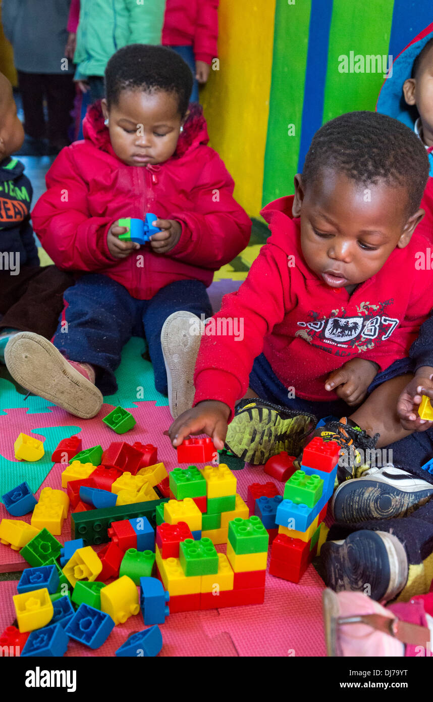 South Africa, Cape Town. Littlle Boy Playing with Plastic Construction Pieces in a Day-care Facility for Young Children. Stock Photo