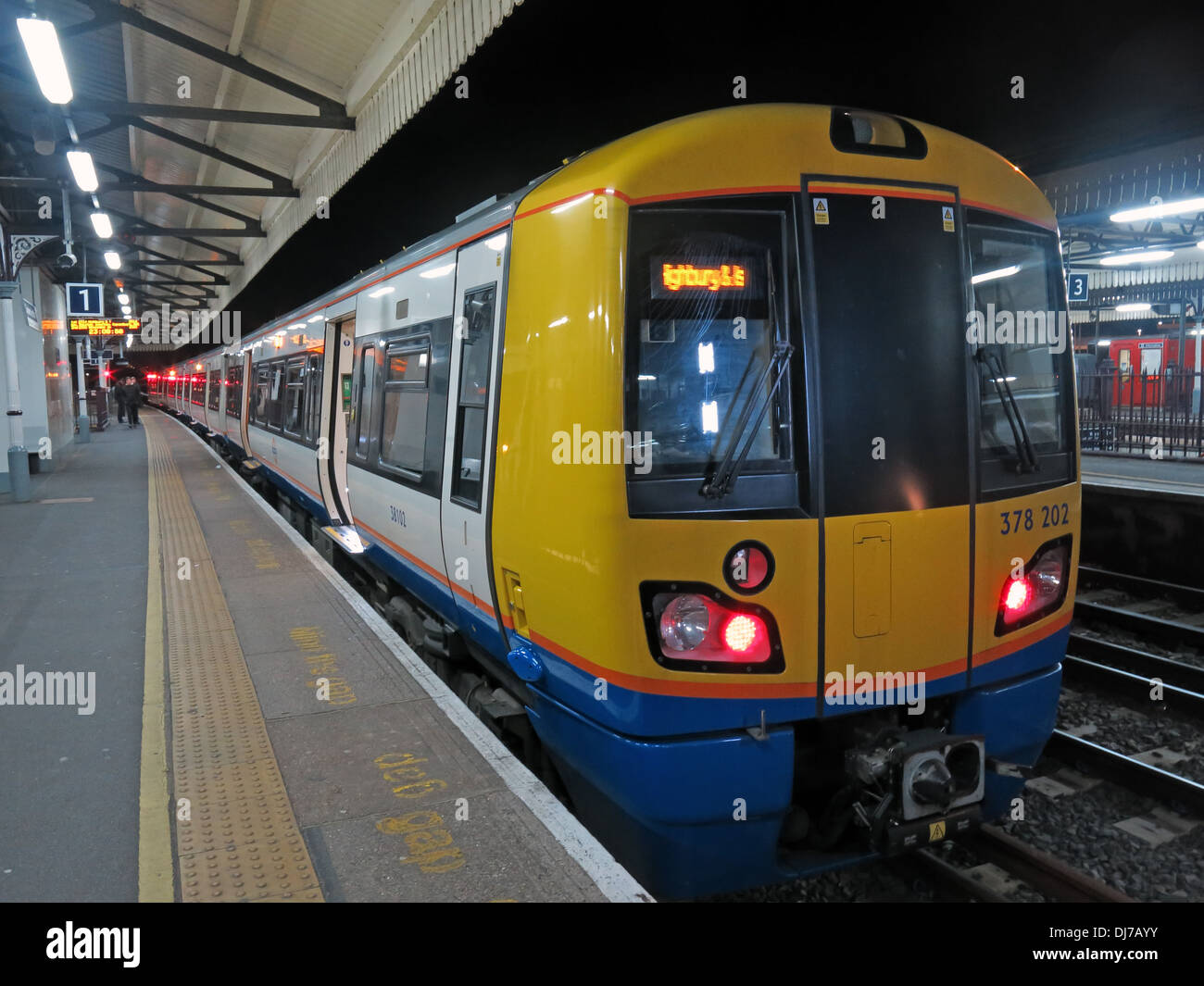 London Overground Class 378 train standing at Clapham Junction station in South West London at night. Stock Photo