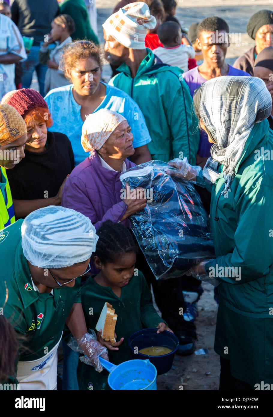 South Africa, Cape Town. Woman receiving a blanket donated by an