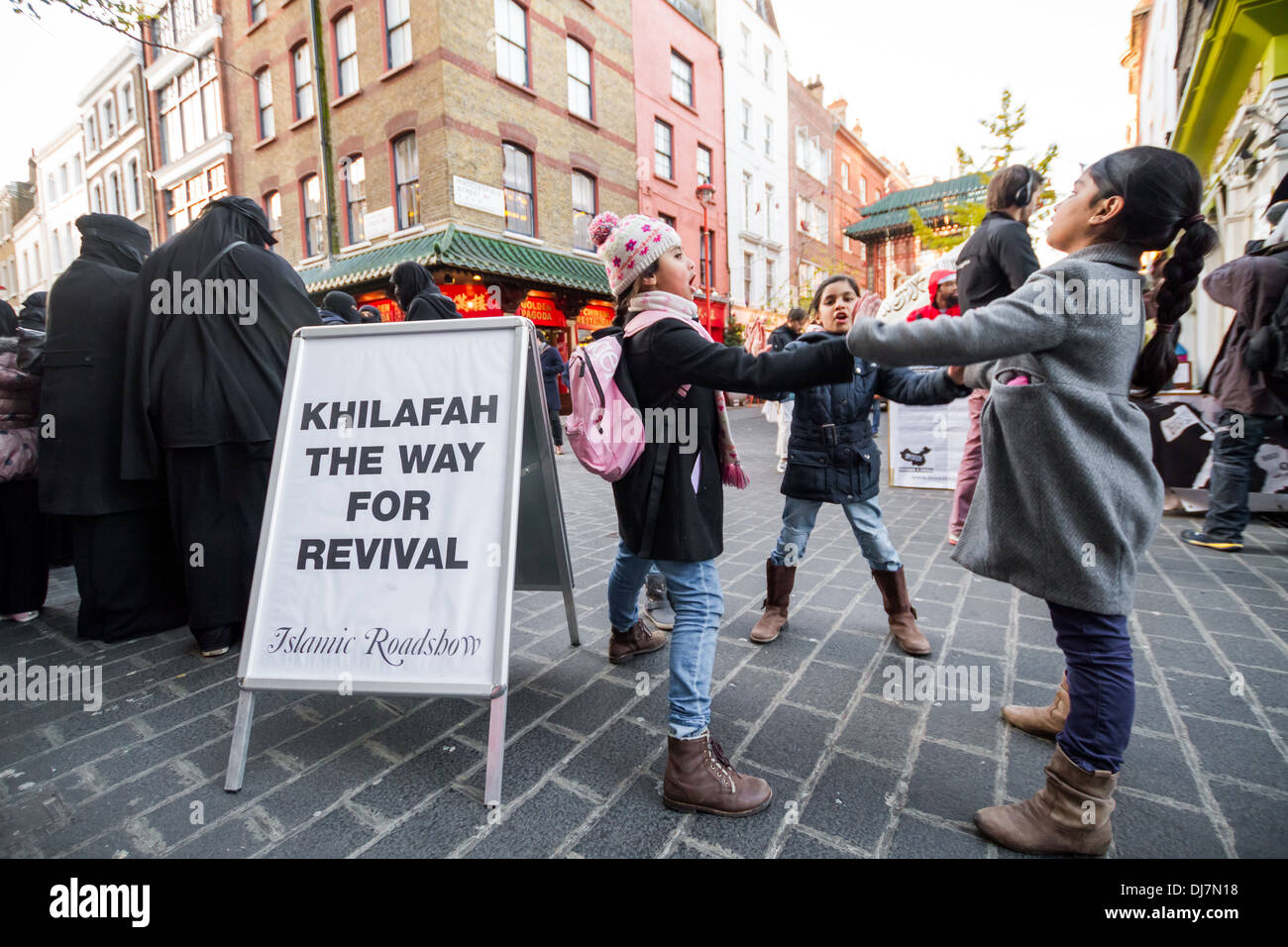 Children of the Islamists play whilst their parents continue to protest in London’s Chinatown. Stock Photo