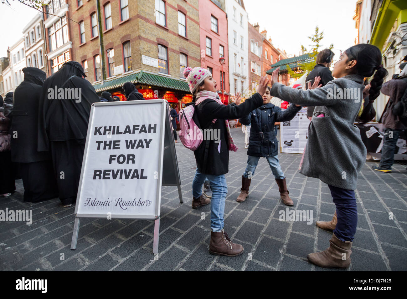 Children of the Islamists play whilst their parents continue to protest in London’s Chinatown. Stock Photo