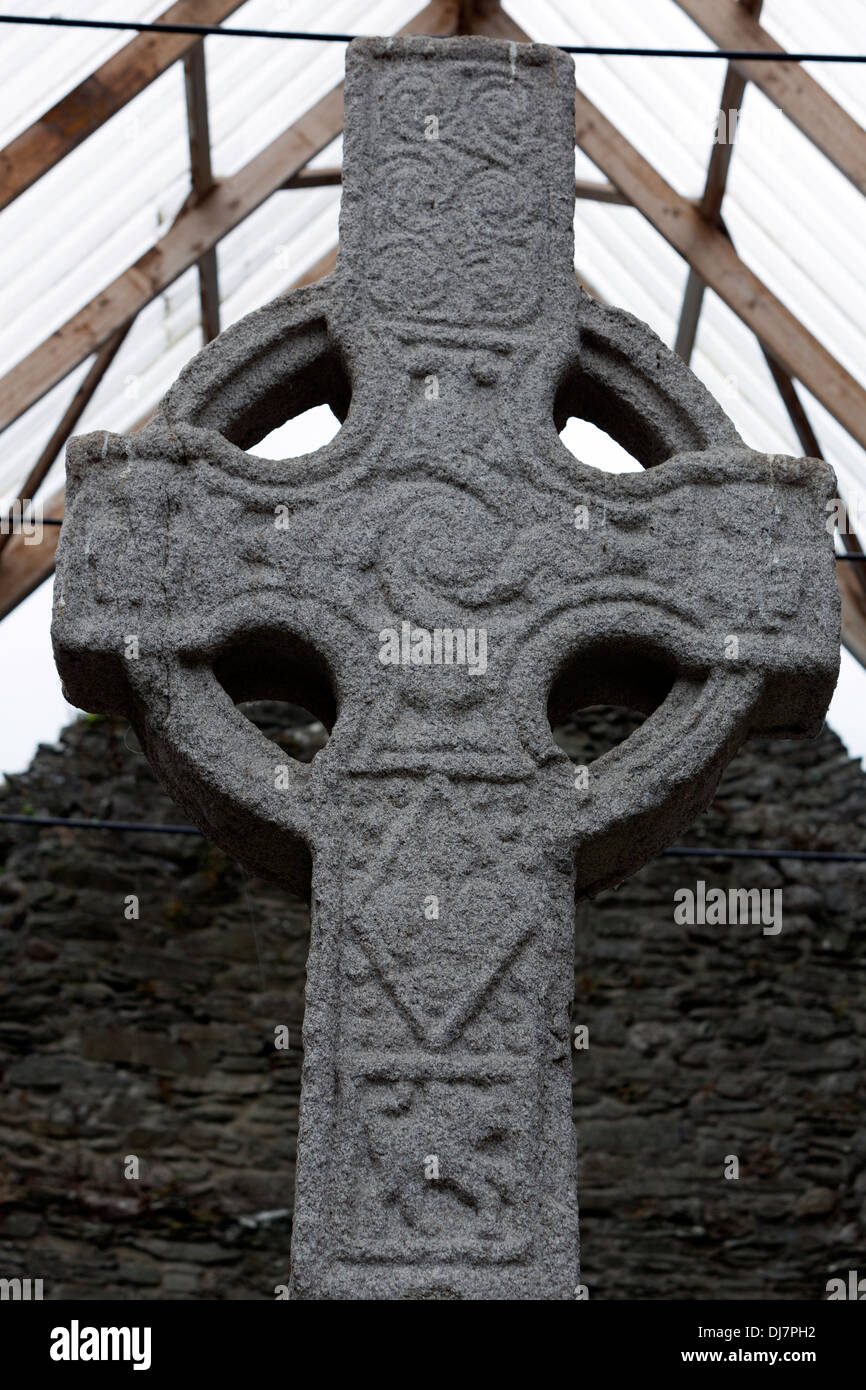 ´Serpents´ uncoiling themselves into the cross arms, flanked by a figure on each side Moone high cross. Stock Photo
