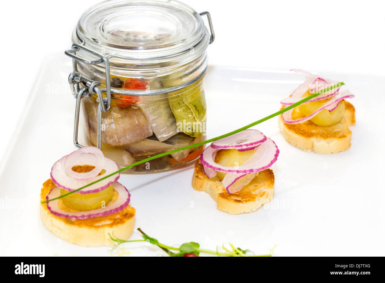 pickled herring in a glass jar with potato canapes Stock Photo Alamy