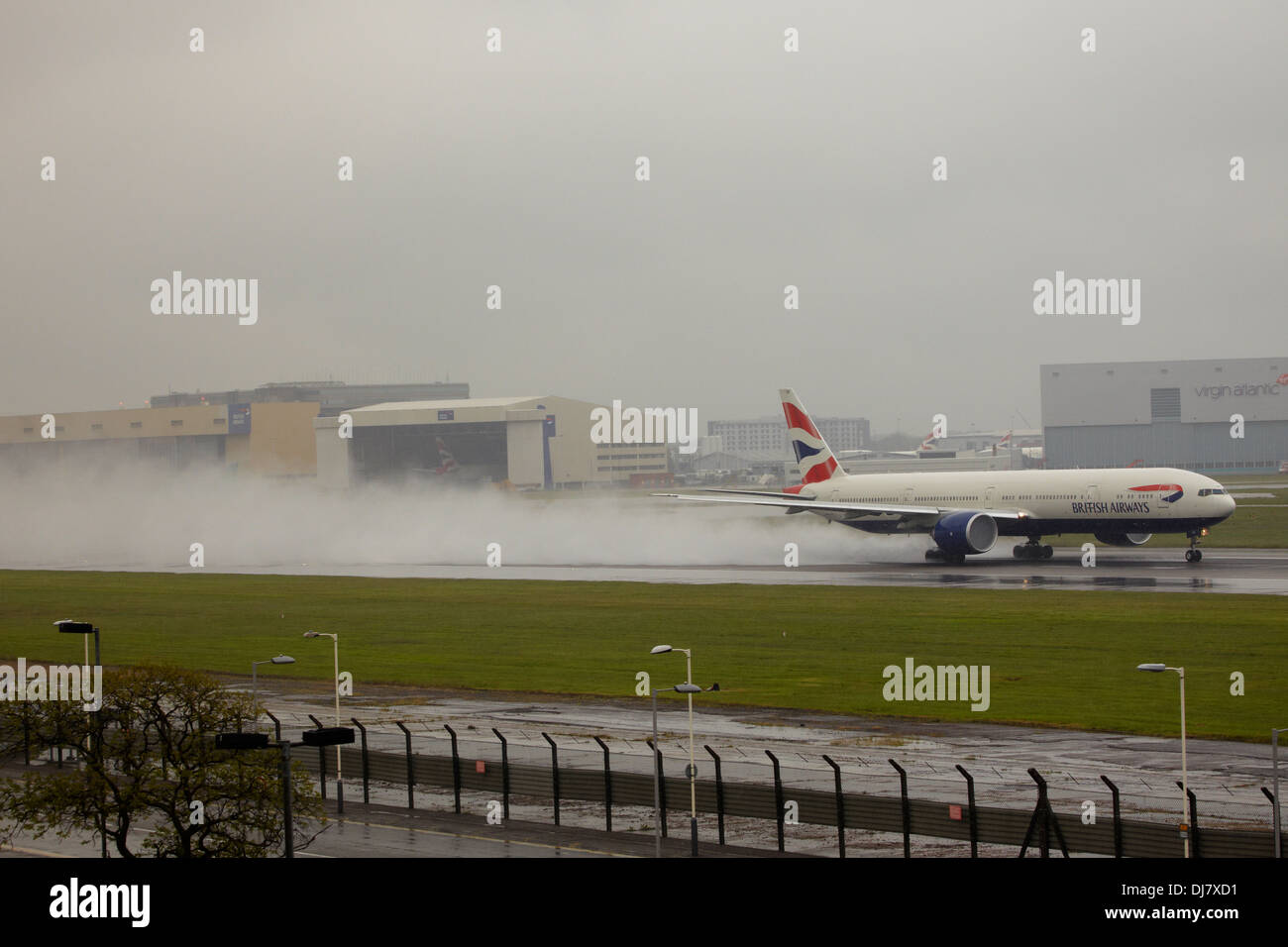 British Airways Boeing 777 jet taking off in bad weather and rain at