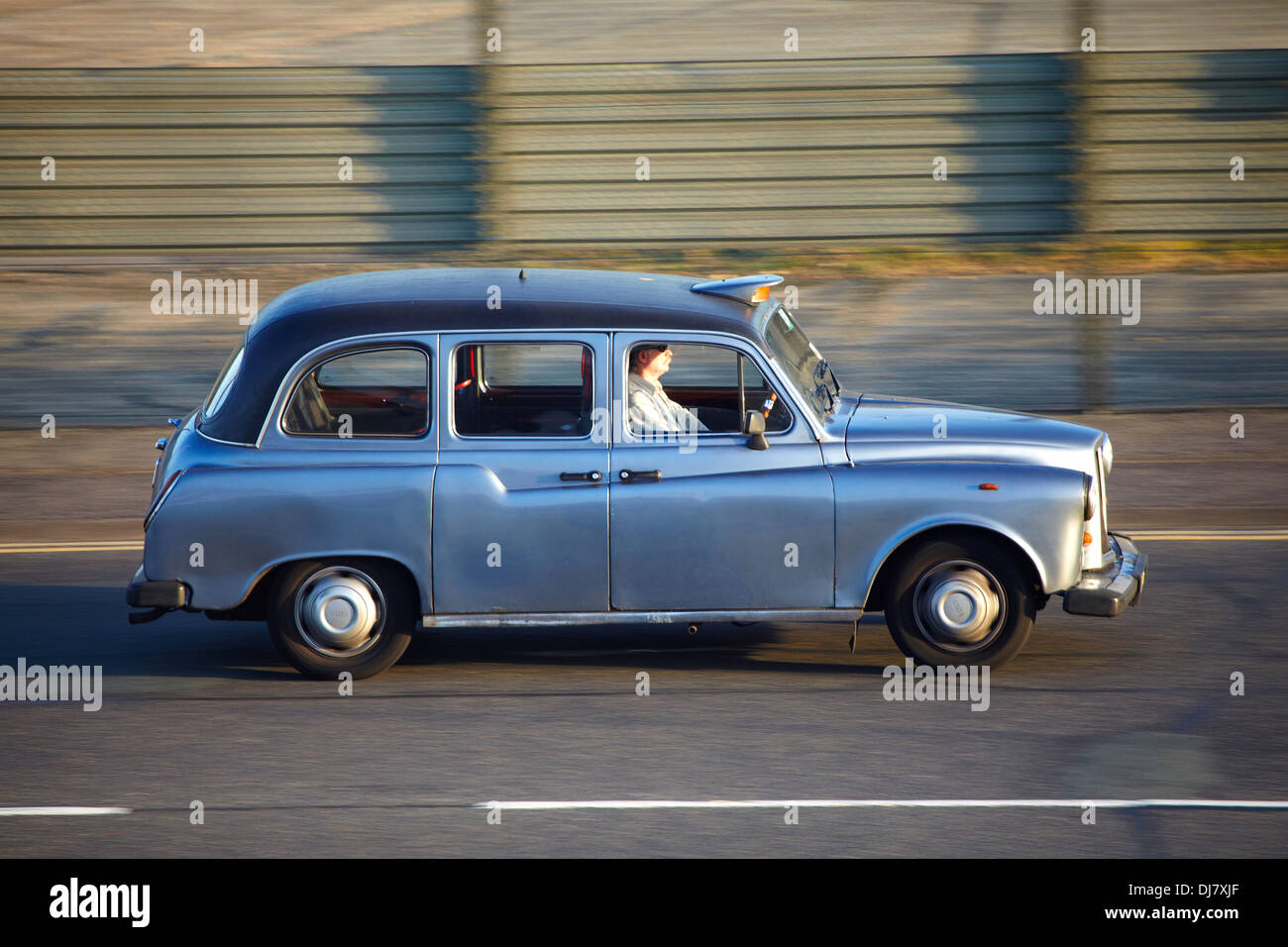 A hackney or hackney carriage (also called a cab, black cab, hack or London taxi) driving in London Stock Photo
