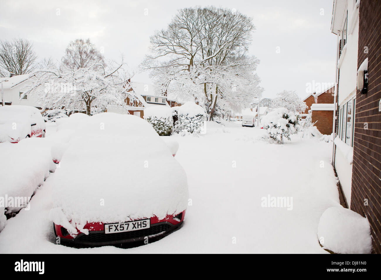 A car covered in deep snow, parked on the driveway of a house Stock Photo