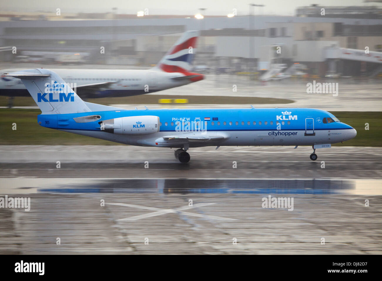 KLM Fokker 70  taking off at London Heathrow Airport in rain and bad weather Stock Photo
