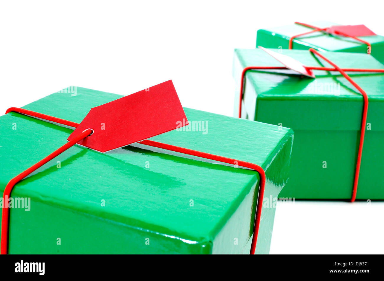 a pile of green and red gifts with a blank label on a white background Stock Photo